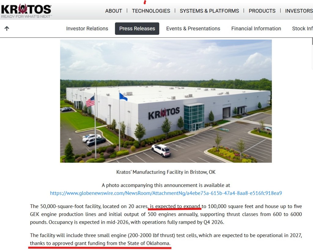 Aerial view of the Kratos Defense & Security Solutions manufacturing facility in Bristow, Oklahoma. The modern building features the company's logo prominently displayed on the front, surrounded by landscaped grounds and parking areas.
